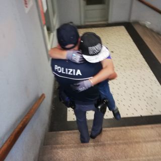 Poliziotto prende in braccio un bambino disabile e lo porta al treno