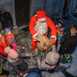 Babbo Natale scende dal campanile e porta doni ai bambini
