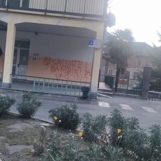 Scritte no vax sulla facciata delle scuole Bagnolini di Villa