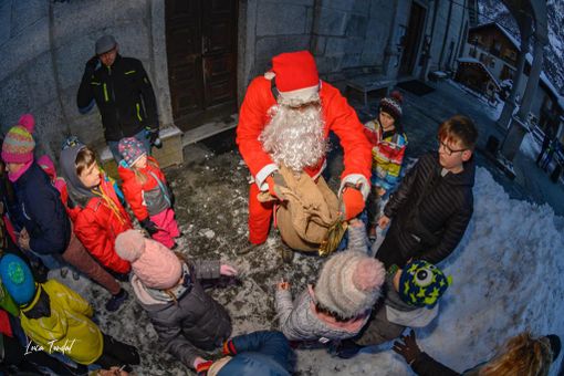 Babbo Natale scende dal campanile e porta doni ai bambini