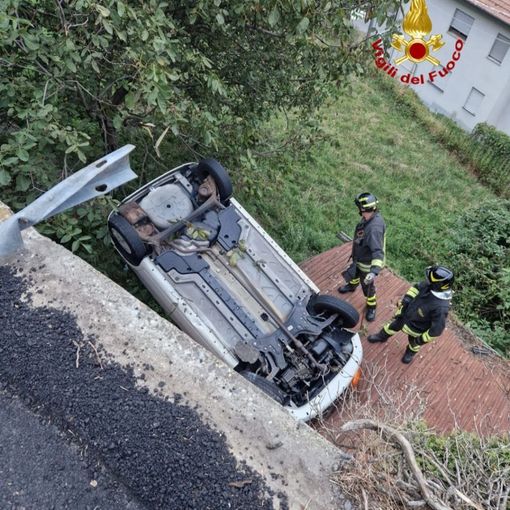 Auto esce di strada e si ribalta sul tetto di una legnaia