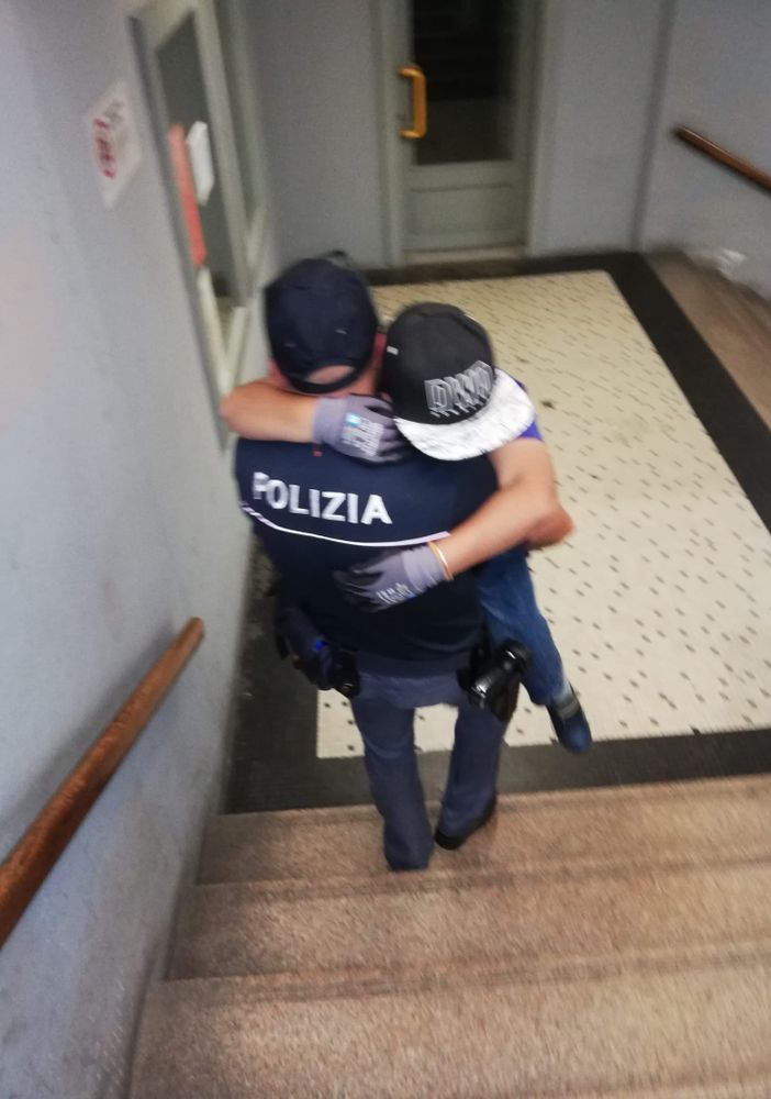 Poliziotto prende in braccio un bambino disabile e lo porta al treno