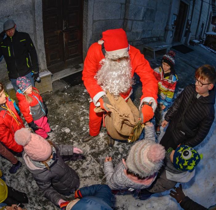 Babbo Natale scende dal campanile e porta doni ai bambini