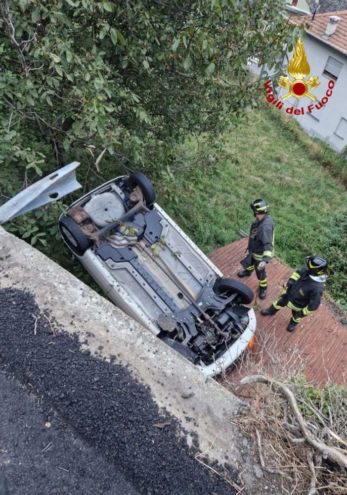 Auto esce di strada e si ribalta sul tetto di una legnaia