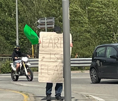 Terrapiattista solitario manifesta con un cartello di fronte all'Eurospin di Domo Terrapiattista solitario manifesta con un cartello di fronte all'Eurospin di Domo