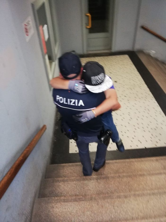 Poliziotto prende in braccio un bambino disabile e lo porta al treno Poliziotto prende in braccio un bambino disabile e lo porta al treno