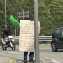 Terrapiattista solitario manifesta con un cartello di fronte all'Eurospin di Domo
